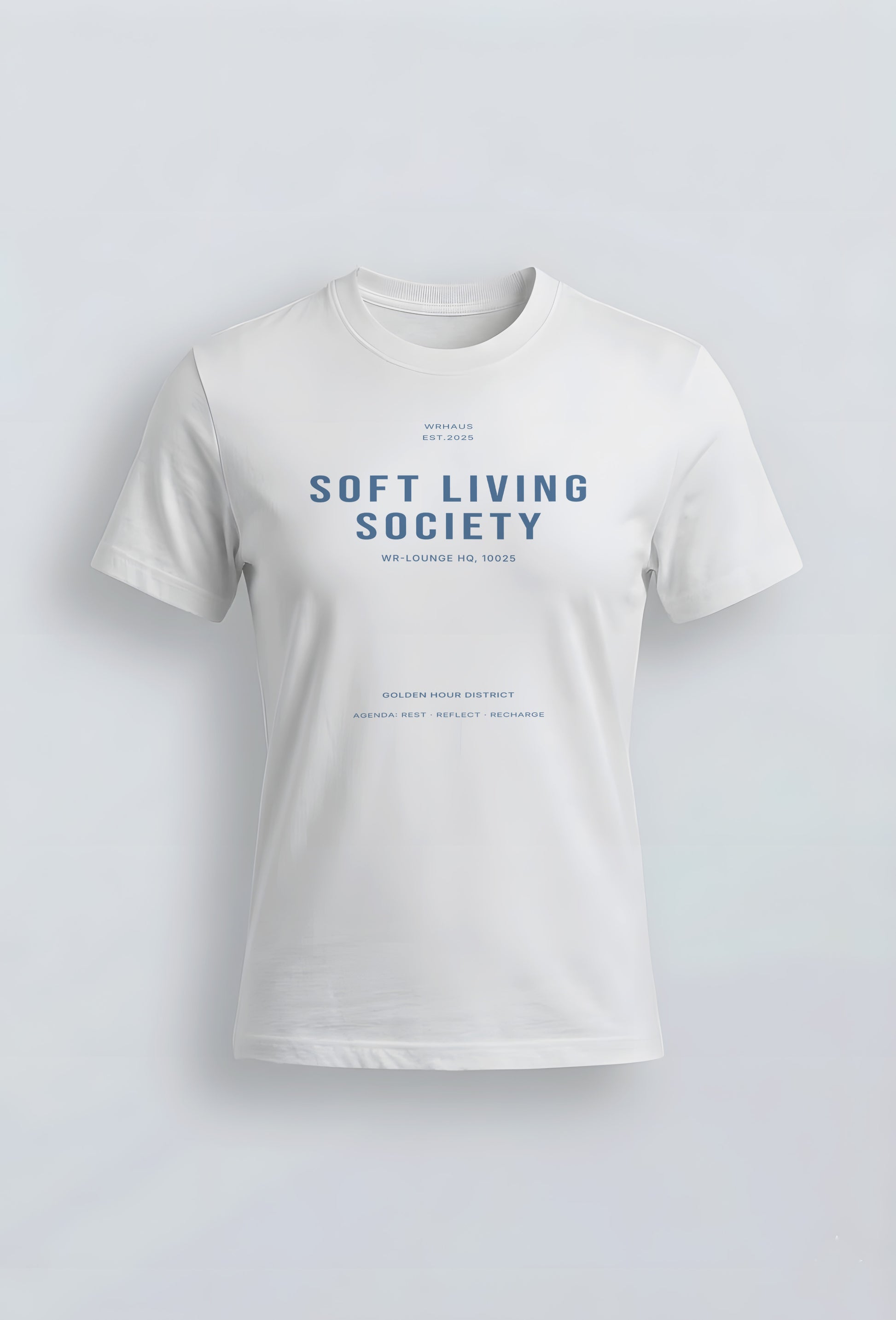A premium white short-sleeved womens fit t-shirt with a structured fit. The center chest features bold, minimalist typographic design that reads "SOFT LIVING SOCIETY" with smaller archival-style details below it.